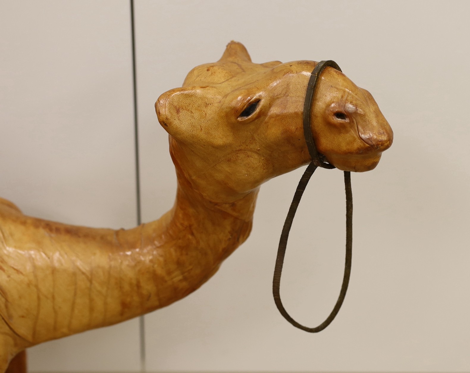 A Liberty style leather bound model of a camel, 64.5cm